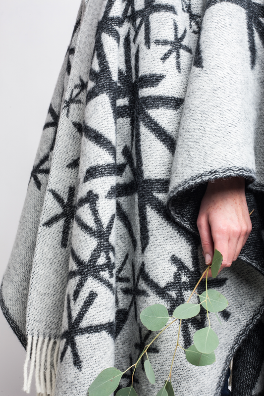 Woman wearing a cape with the strength runes